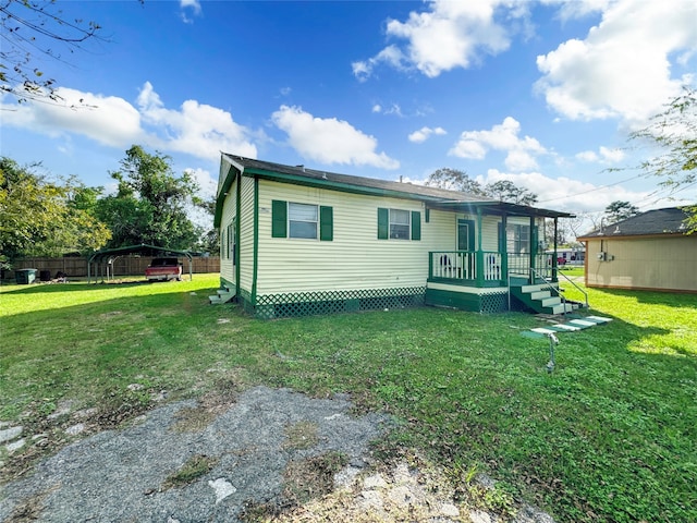 rear view of property featuring a yard and a carport