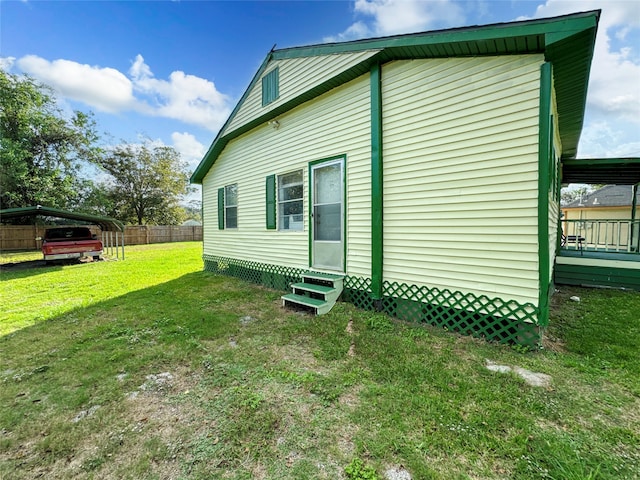 back of house with a lawn and a carport