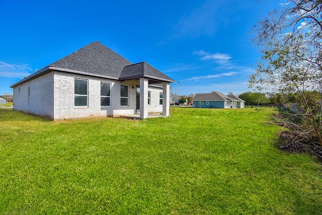 209 Silverleaf Rd, Sweeny, TX 77480 - back of property featuring a shingled roof, brick siding, and a lawn