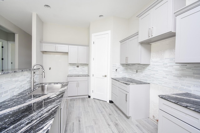 209 Silverleaf Rd, Sweeny, TX 77480 - kitchen featuring a sink, backsplash, light stone countertops, and light wood finished floors