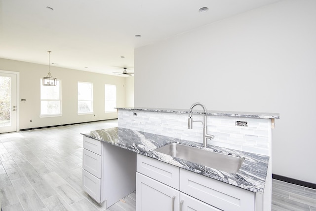 209 Silverleaf Rd, Sweeny, TX 77480 - kitchen featuring a sink, plenty of natural light, light stone countertops, and ceiling fan