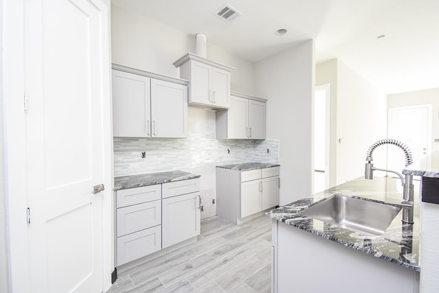 209 Silverleaf Rd, Sweeny, TX 77480 - kitchen featuring a sink, stone counters, backsplash, and light wood-style flooring
