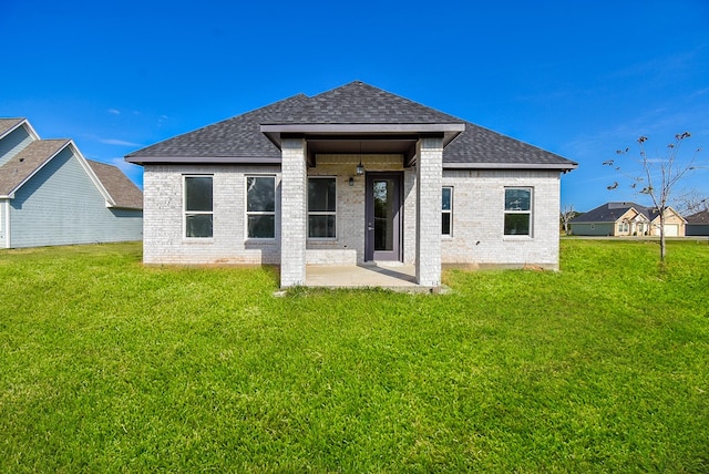 rear view of property featuring a lawn