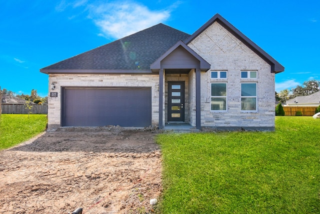 view of front of property featuring a garage and a front lawn