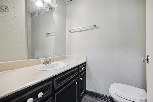 bathroom with hardwood / wood-style floors, vanity, and toilet