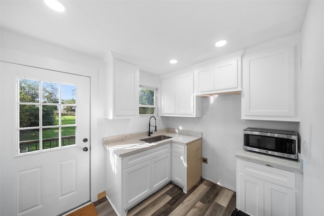 kitchen with white cabinets, sink, and dark wood-type flooring