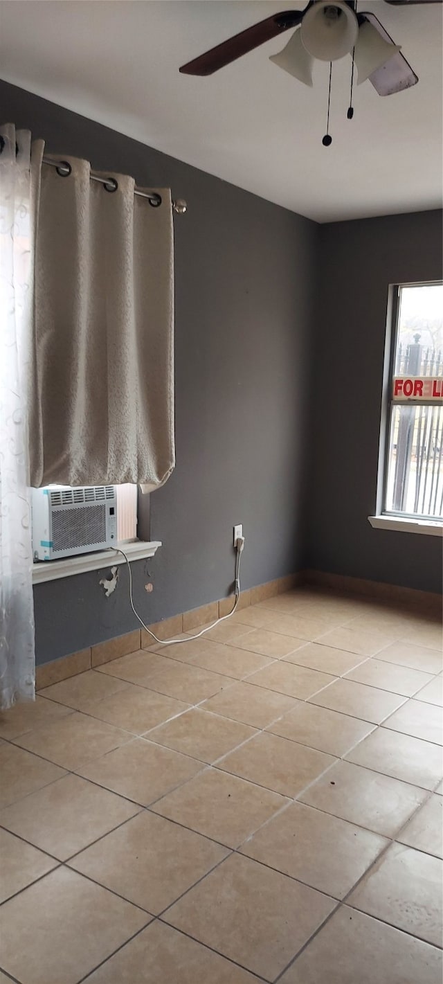 unfurnished room featuring cooling unit, ceiling fan, and light tile patterned flooring