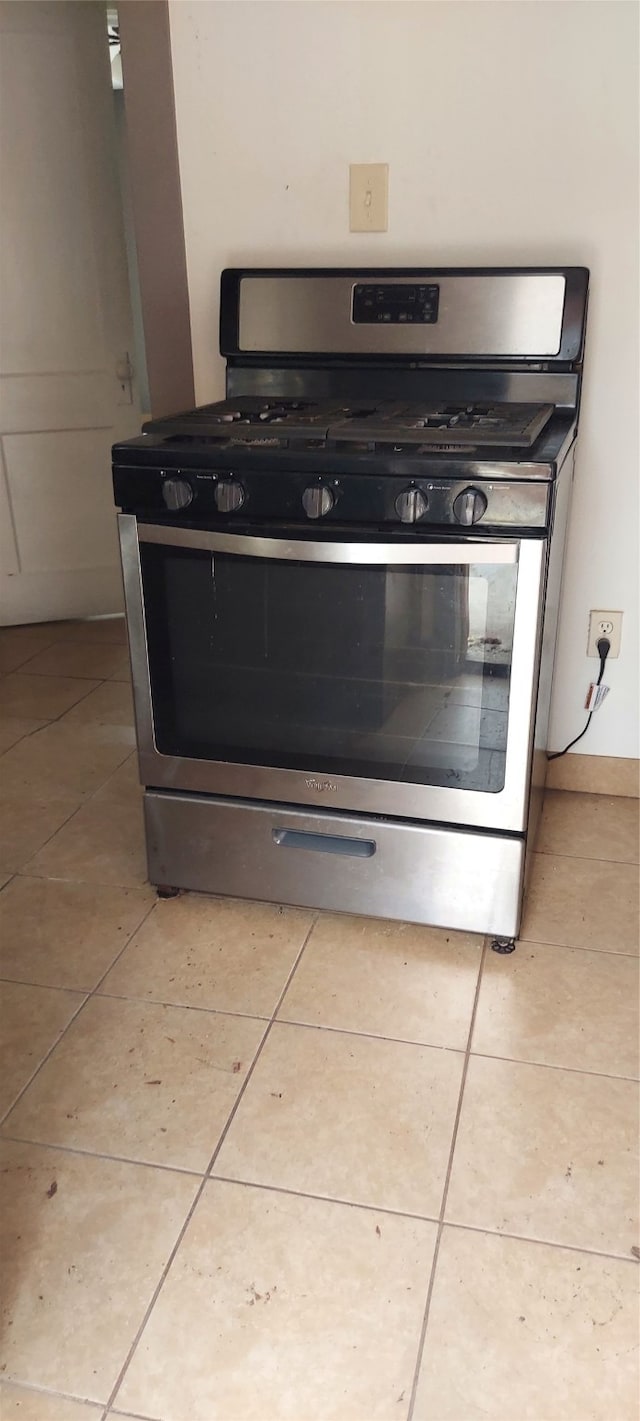 interior details with stainless steel gas stove and light tile patterned floors