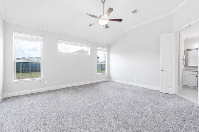 carpeted empty room with ceiling fan, ornamental molding, and vaulted ceiling