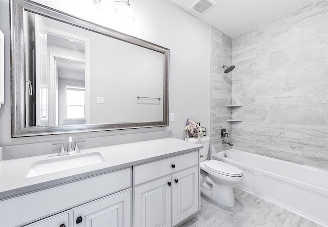 full bathroom featuring vanity, tiled shower / bath combo, and toilet