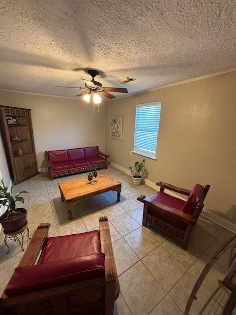 living room featuring ceiling fan, crown molding, light tile patterned floors, and a textured ceiling