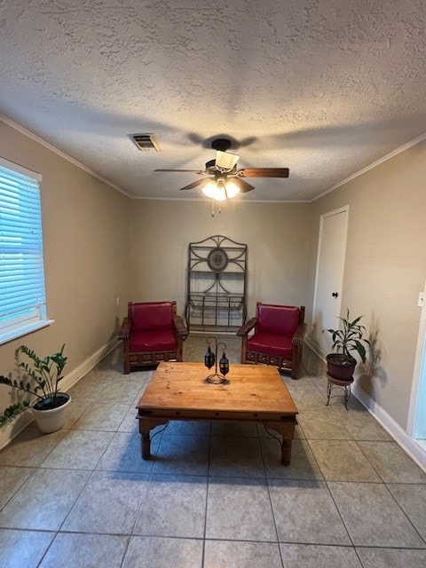 interior space featuring a textured ceiling, ceiling fan, light tile patterned floors, and crown molding