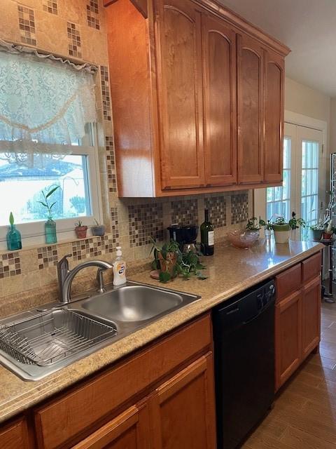 kitchen featuring dishwasher, french doors, sink, dark hardwood / wood-style floors, and decorative backsplash