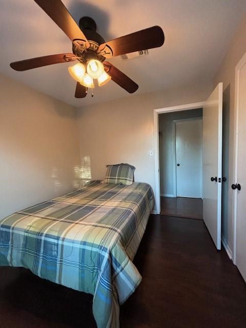 unfurnished bedroom with ceiling fan and dark wood-type flooring