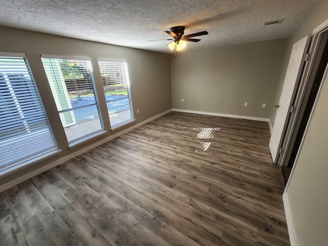 spare room with dark hardwood / wood-style flooring, a textured ceiling, and ceiling fan