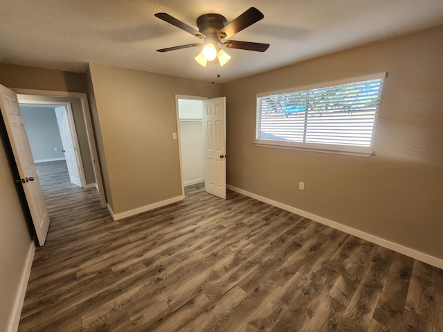 unfurnished bedroom featuring ceiling fan and dark wood-type flooring