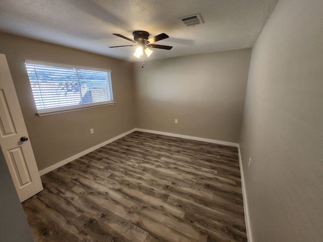 empty room featuring ceiling fan, dark hardwood / wood-style floors, and a textured ceiling