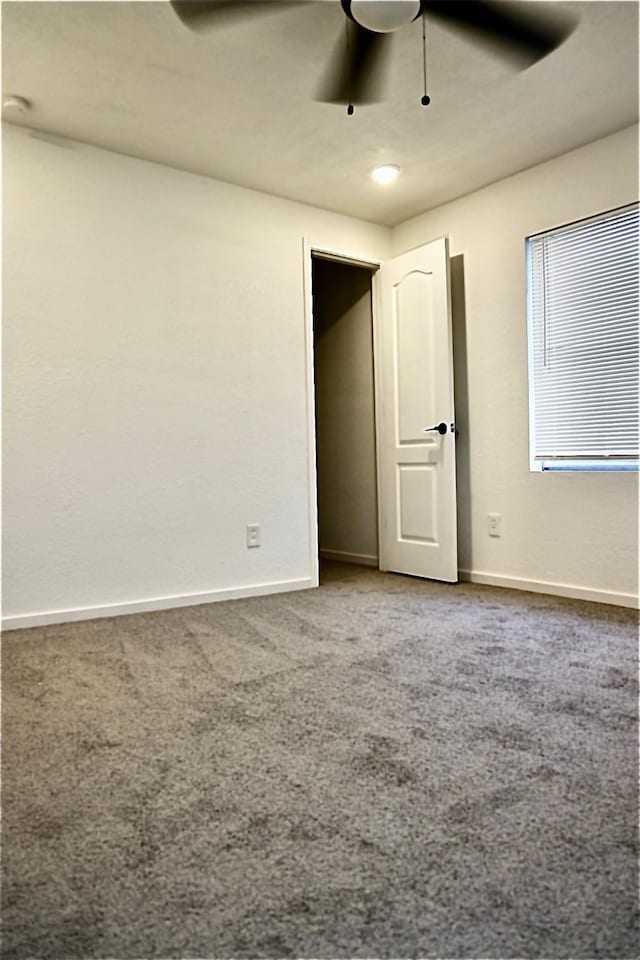 unfurnished bedroom with ceiling fan and carpet flooring