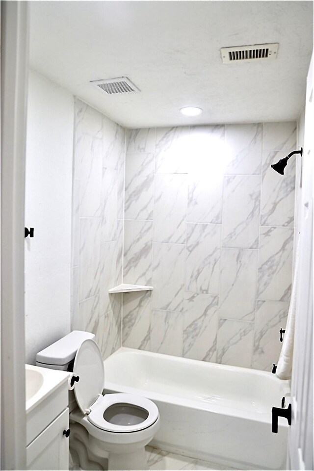 full bathroom with tiled shower / bath combo, toilet, and vanity