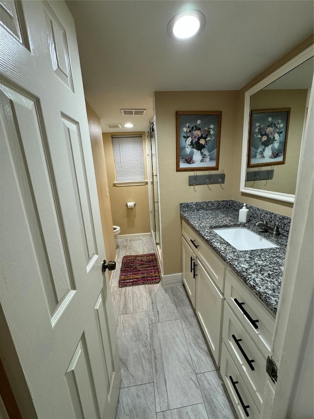 full bathroom with marble finish floor, visible vents, toilet, a stall shower, and vanity