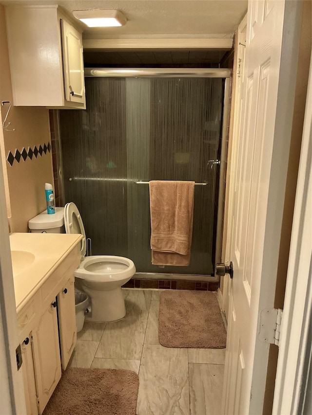 bathroom featuring a shower stall, toilet, and vanity