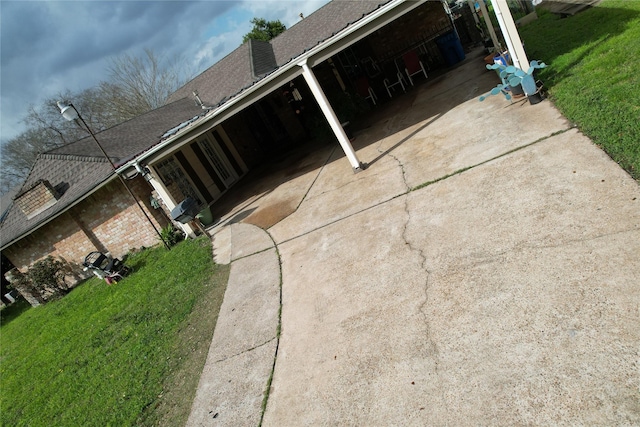 view of property exterior featuring a shingled roof and a lawn