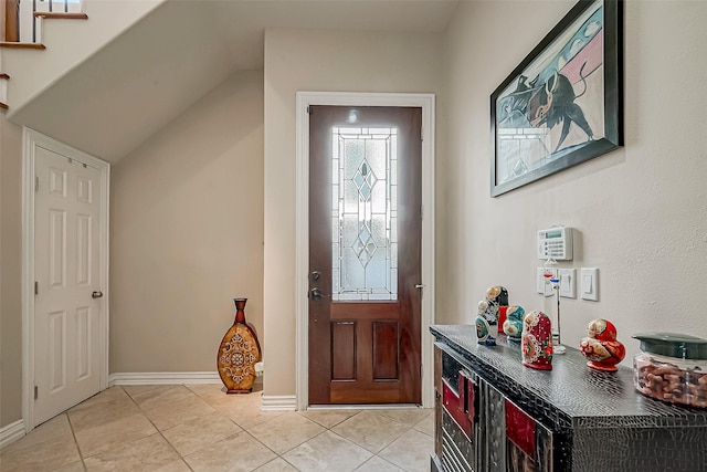 tiled foyer entrance with vaulted ceiling