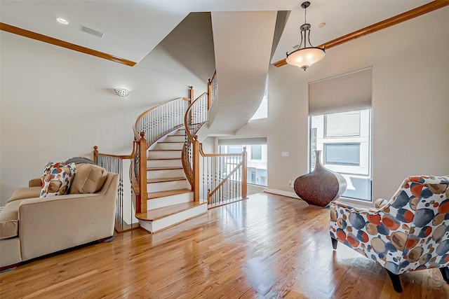 sitting room with a high ceiling and light hardwood / wood-style floors