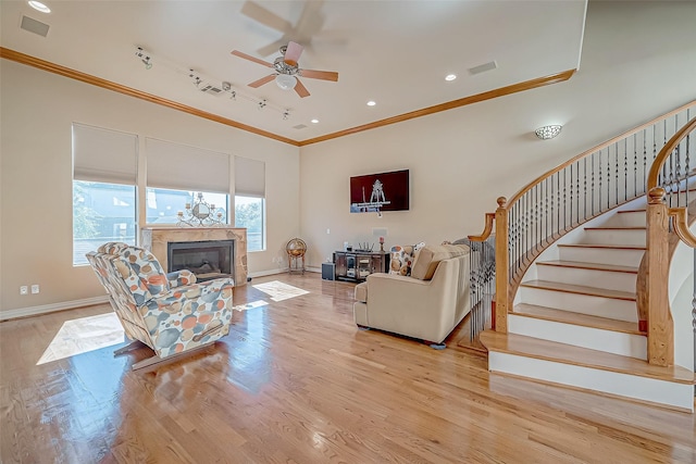 living room with track lighting, light hardwood / wood-style flooring, ceiling fan, and ornamental molding