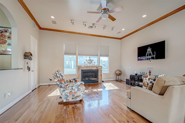 living room featuring light wood-type flooring, ceiling fan, and ornamental molding