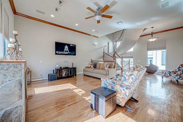 living room featuring crown molding, ceiling fan, and light wood-type flooring