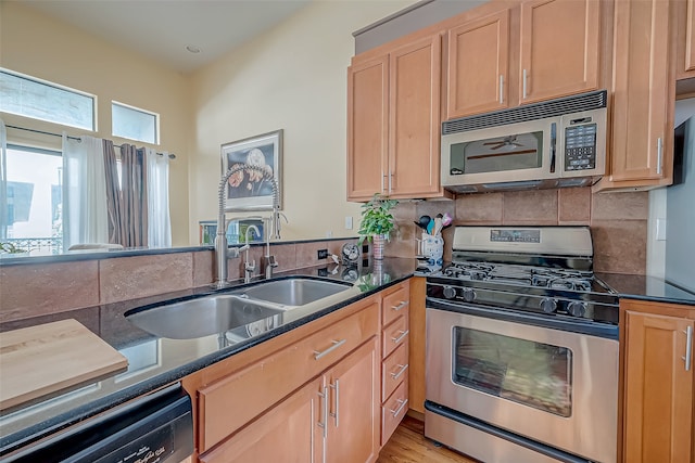 kitchen with decorative backsplash, sink, stainless steel appliances, and light hardwood / wood-style flooring