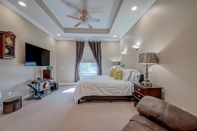 carpeted bedroom with ceiling fan, ornamental molding, and a tray ceiling