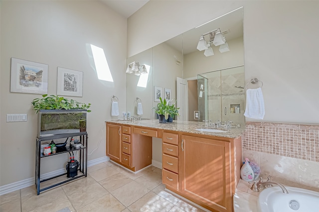 bathroom featuring a skylight, tile patterned flooring, vanity, and a bathtub