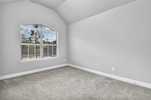 empty room featuring carpet flooring and lofted ceiling