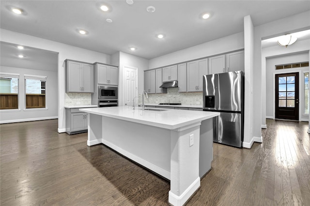 kitchen with gray cabinets, sink, stainless steel appliances, and a kitchen island with sink