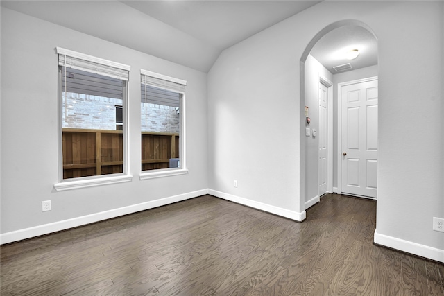 empty room with dark hardwood / wood-style flooring and lofted ceiling