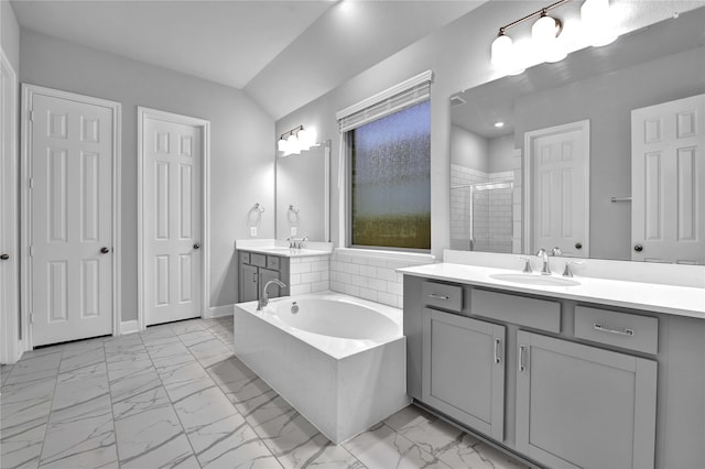 bathroom featuring separate shower and tub, vanity, and lofted ceiling