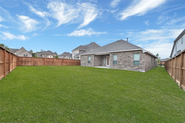 rear view of property featuring a lawn