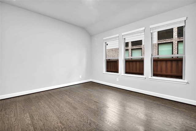 spare room featuring hardwood / wood-style flooring, vaulted ceiling, and a healthy amount of sunlight