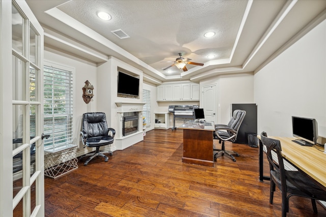 office space with a raised ceiling, ceiling fan, a textured ceiling, and dark hardwood / wood-style floors