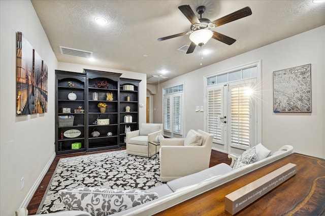 living room featuring dark hardwood / wood-style floors, ceiling fan, a textured ceiling, and french doors