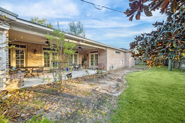 back of house with a yard, ceiling fan, and a patio area