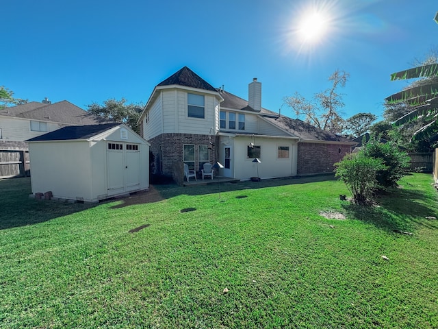 rear view of house featuring a lawn and a storage unit