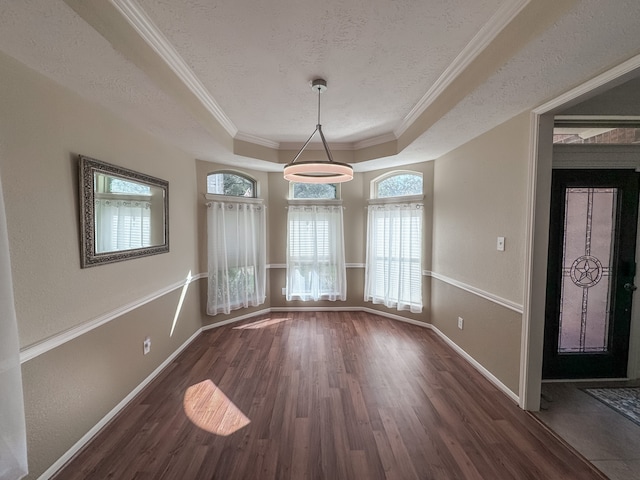 unfurnished dining area with a raised ceiling, crown molding, a healthy amount of sunlight, and dark hardwood / wood-style floors