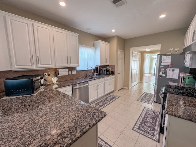 kitchen with stainless steel appliances, white cabinetry, and plenty of natural light