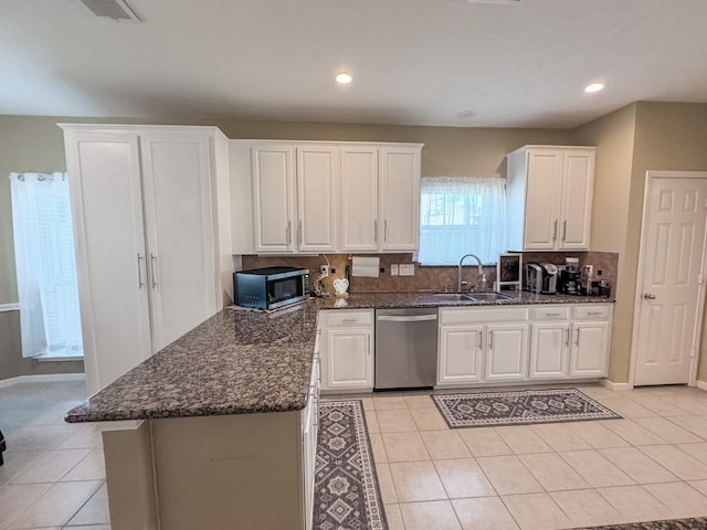 kitchen with white cabinets, sink, light tile patterned floors, and stainless steel appliances