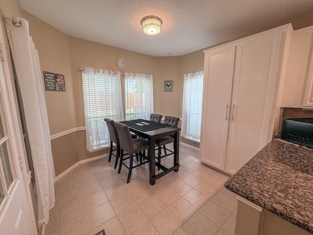 tiled dining room with a textured ceiling