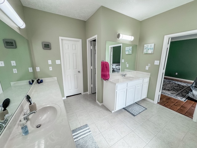 bathroom with vanity, a textured ceiling, and tile patterned floors