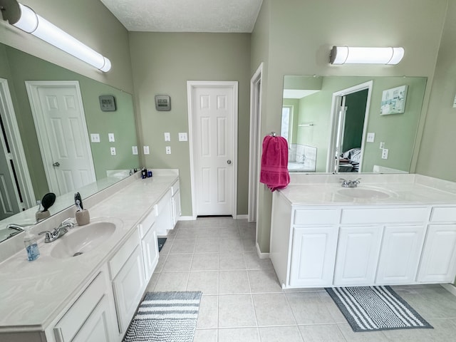 bathroom featuring tile patterned floors, vanity, and a textured ceiling